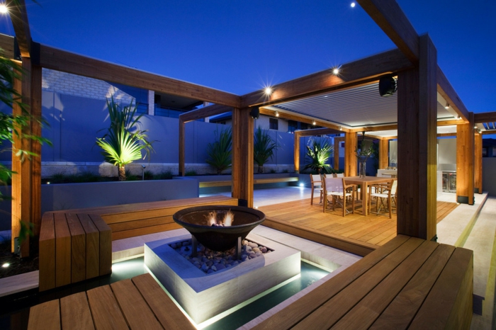 diseño innovador, grande terraza con elementos de madera, decoracion terrazas con lámparas empotradas, chimenea original, bancos de madera