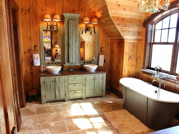 baños rústicos decorados en tonos terrosos y cálidos, bañera y armario vintage, paredes de madera y candelabro vintage