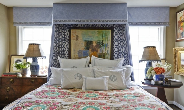 precioso interior con muchas decoración de cuadros, cortinas vintage en azul violeta, cama doble con muchos cojines decorativos