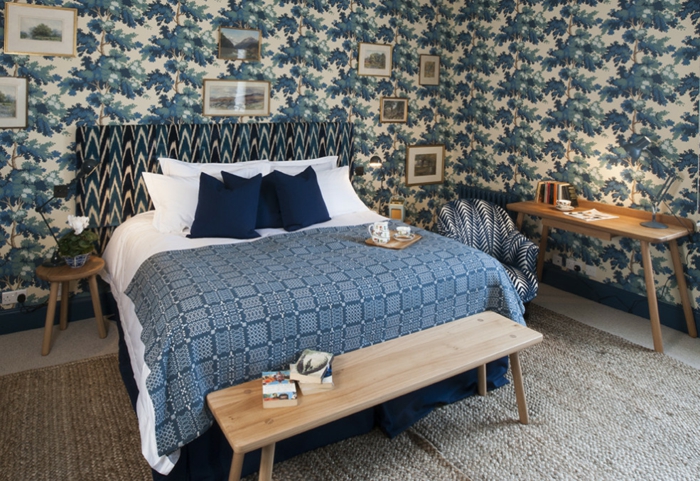 habitación en estilo vintage con muchos cuadros decorativos pequeños, cama con cabecero en estampado original