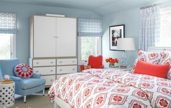 habitación acogedora decorada con detalles en azul celeste y rojo, muebles vintage y decoración de cuadros 