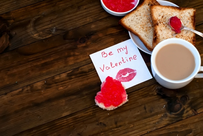 propuesta originales para regalos romanticos, desayuno con tostadas y café y hoja de papel con mensaje de amor 