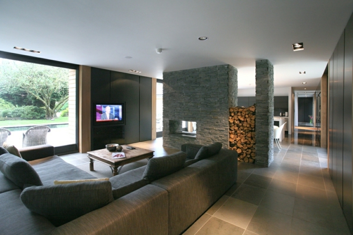 separadores de ambientes, grande espacio decorado en gris, salón espaciosos con separador de ambientes de ladrillos, grande ventanal con vista