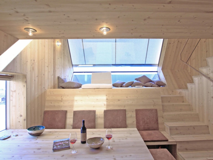 mini casa, interior de una vivienda mini, revestimiento de madera y lámparas empotradas, techo inclinado con grande ventanal 