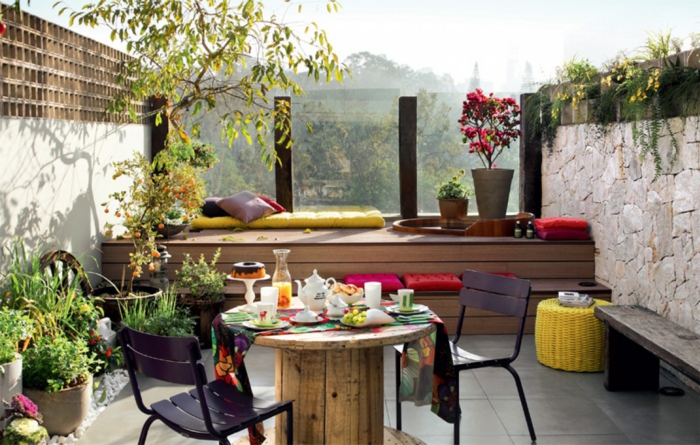pequeña terraza coqueta, cómo decorar terrazas de pequeño tamaño, muchos objetos decorativos, mesa de madera y macetas con plantas verdes