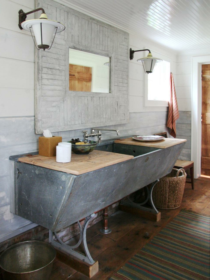 estilo rústico moderno, muebles auxiliares de baño, lavabo grande de obra con encimera de madera, espejo grande con marco de palets, suelo de tarima tapete
