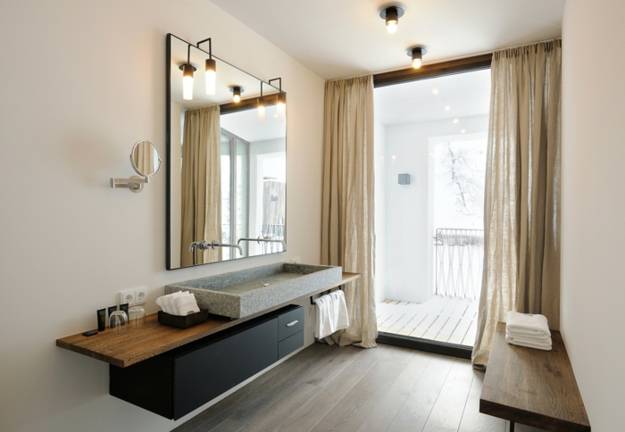 ba;o en beige, lavabo grande de granito, espejo cuadrado, mueble baño, color negro de madera, ventanal con cortinas, terraza