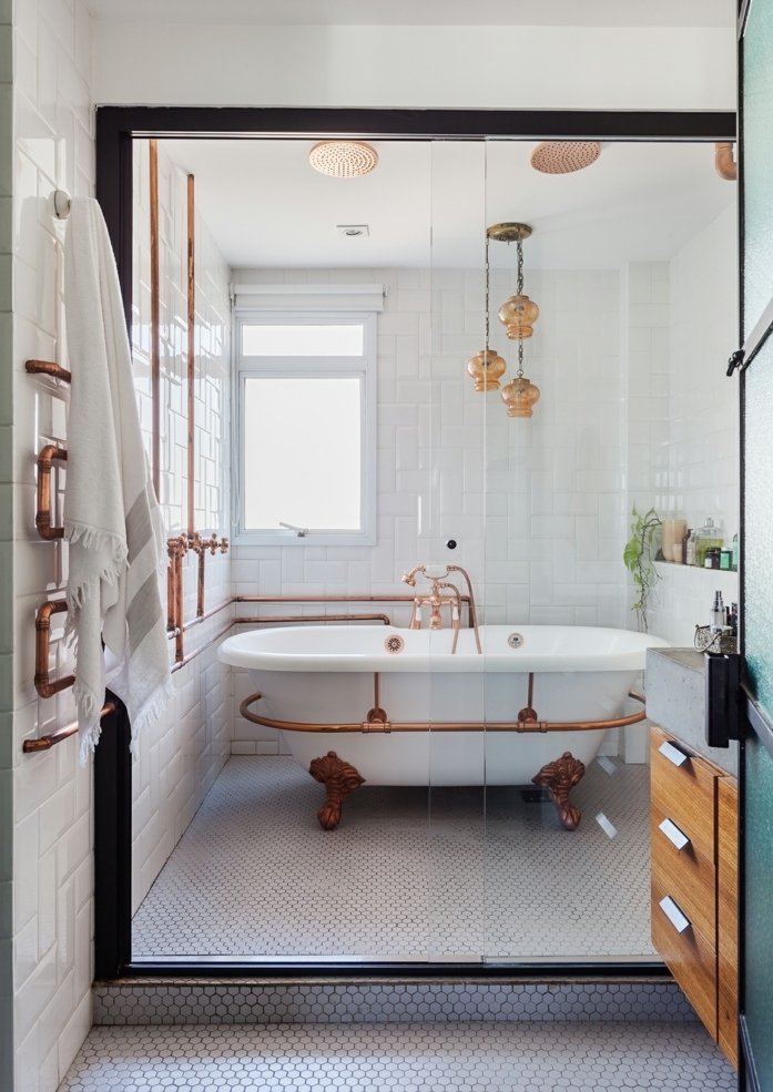 baño blanco, bañera con tubos en cobrizo, mámpara de vidrio, mueble baño, madera, lámpara colgante, ladrillo cisto esmaltado, luz natural