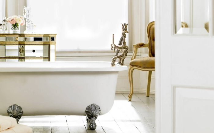 decoración baño de lujo, mueble baño, bañera con patas de garra plateados, sillón, armario en dorado, rosas y ventana grande