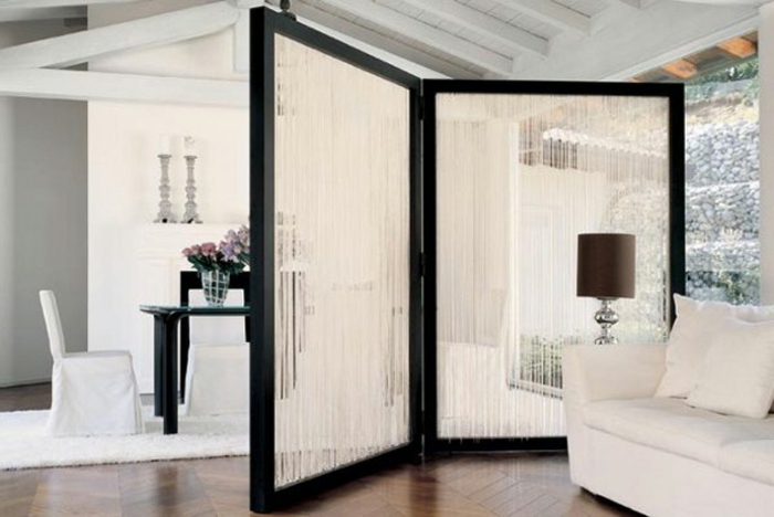 separador de ambientes, grande salón elegante en blanco y negro, separador de ambientes de dos partes plegable, suelo de parquet con alfombra peluda blanca
