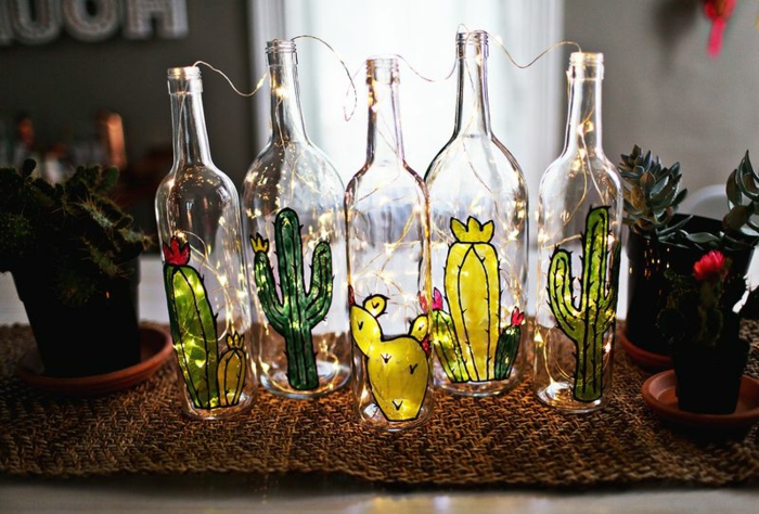 preciosa decoración hecha a mano para el hogar. botellas de cristal dibujadas con cactus con lamparillas dentro 