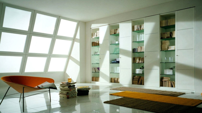 decoración moderna, estanterias de pared. librería empotrada con estantes de vidrio y puertas blancas, ventana inclinada, tapetes, sillón