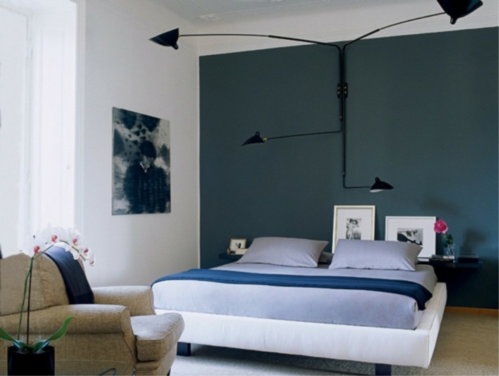 habitación pintada en blanco y azul, con lámpara de diseño muy original, cuadros decorativos modernos