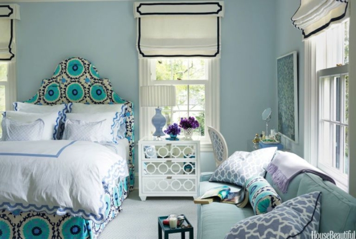 habitación en estilo ecléctico con estores modernos, cama y cuadros vintage, cabecero en arco con estampado en color aguamarina