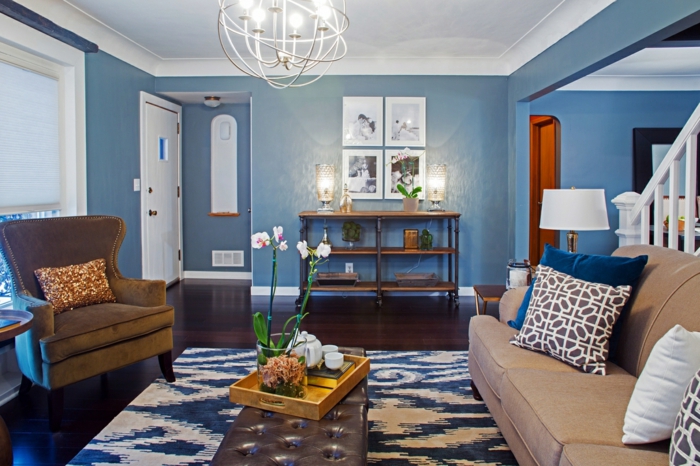 salon moderno, paredes en azul con techo blanco, decoración clásica con sofá, sillón y tapete, fotografias en blanco y negro