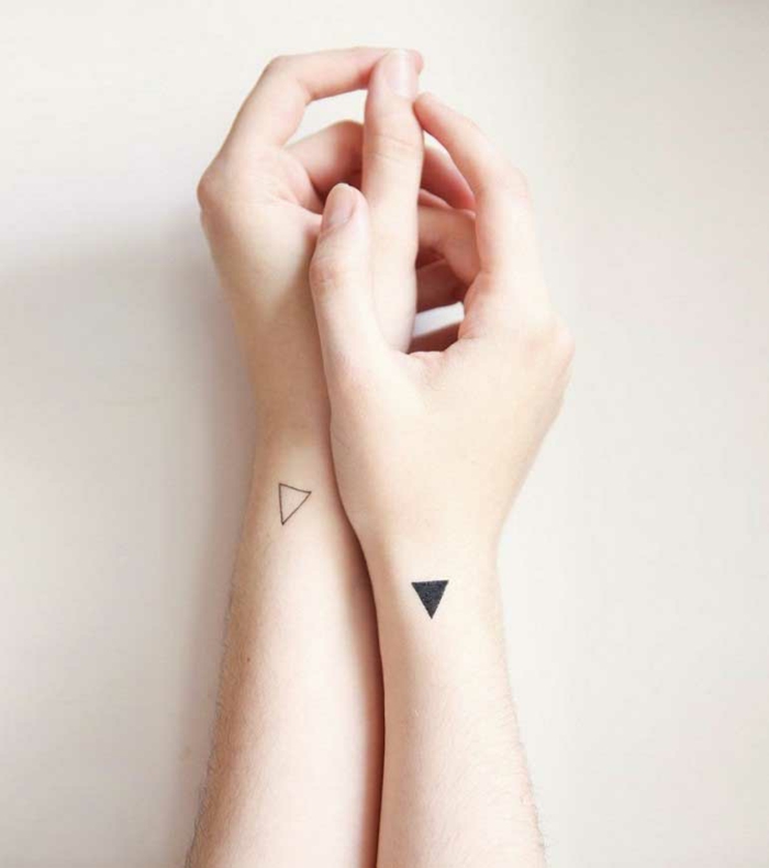 idea de tatuajes para parejas, tatuajes pequeños originales, triángulos minimalistas en la parte lateral de la muñeca, manos con piel blanca