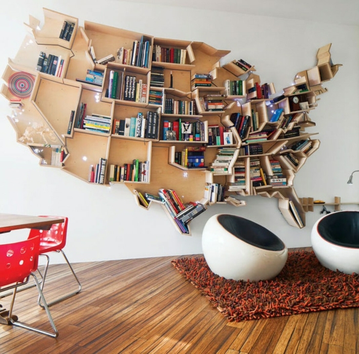 librería original en forma de mapa de Estados Unidos, baldas de madera, salón moderno con tapete peludo y mesa con sillas rojas de plástico y metal