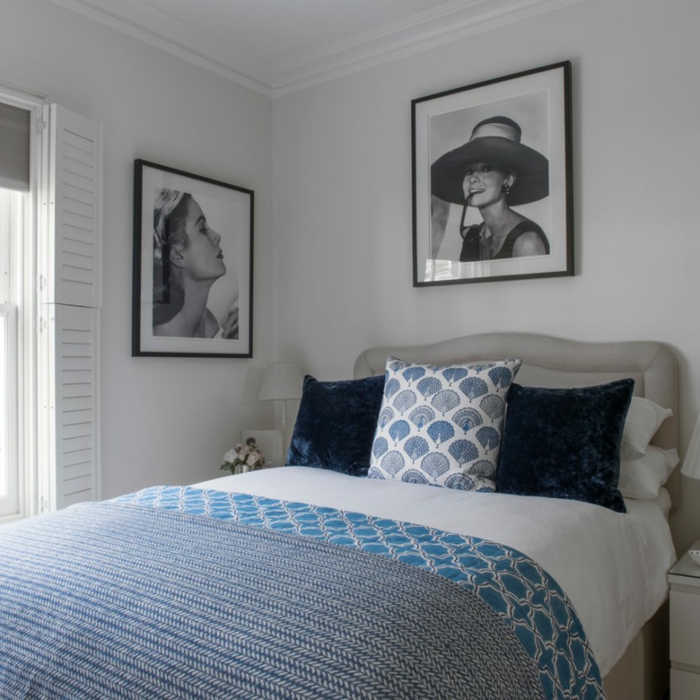 habitación pequeña y acogedora decorada de cuadros vintage en blanco y negro, cama vintage con cabecero 