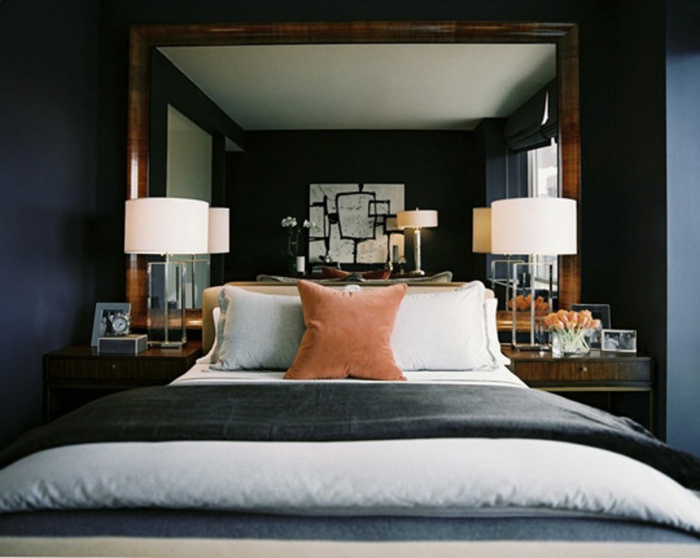 habitación doble con cama con cabecero en beige, cuadros vintage para decorar habitaciones, paredes en azul y grande espejo 