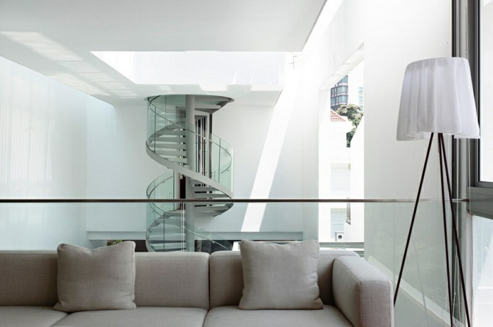 escaleras, interior moderno en bñlanco y gris, escalera de caracol grande con escalones de metal y barandilla de vidrio