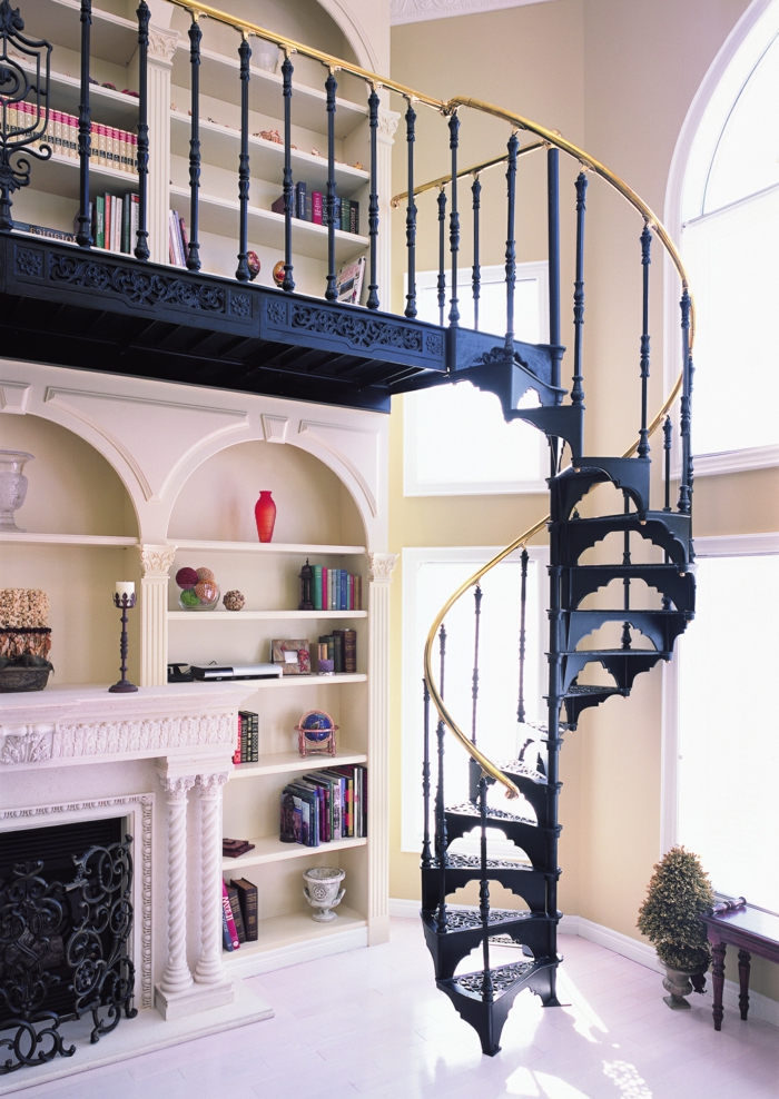 escaleras de caracol, casa con decoración clásica, chimenea y biblioteca, escalera de metal negra con barandilla en dorado