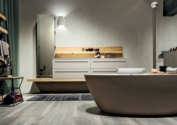 baño moderno pequeño, muebles auxiliares, bañera ovalada, suelo de tarima, armarios de plástico y madera, tapete