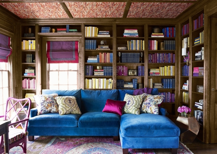 librerias, salón vintage en ciclamen y azul, sofá grande de terciopelo, librería empotrada de madera rustica, ventana con corina, alfombra