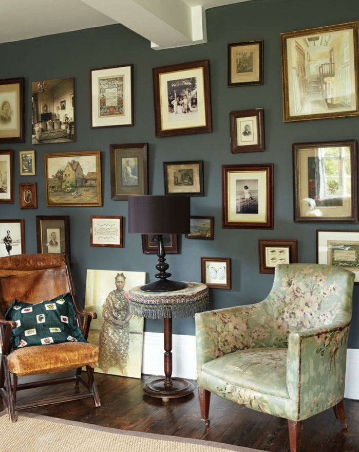 ideas para fotos, precioso salón en estilo vintage con pared pintada en color oscuro y muchos marcos de madera con fotos viejas