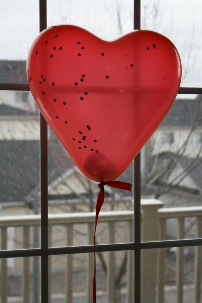 sorpresas romanticas para tu pareja, globo en color rojo con un mensaje romántico dentro, ideas inspiradoras para el 14 de febrero 
