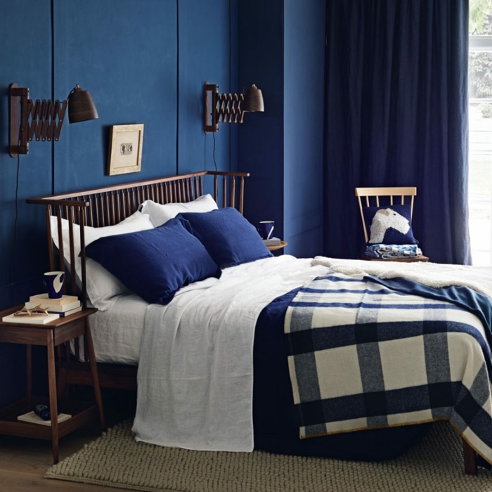 colores habitacion atrevidos, ambiente en azul oscuro, pequeño cuadro decorativo encima de la cama, lámparas vintage