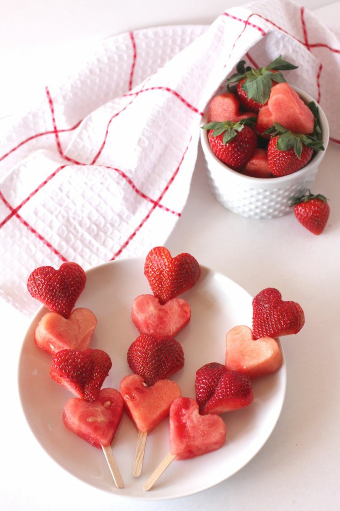 pequeño desayuno hecho de frutas cortadas en forma de corazón, sorpresas románticas con fresas y sandia