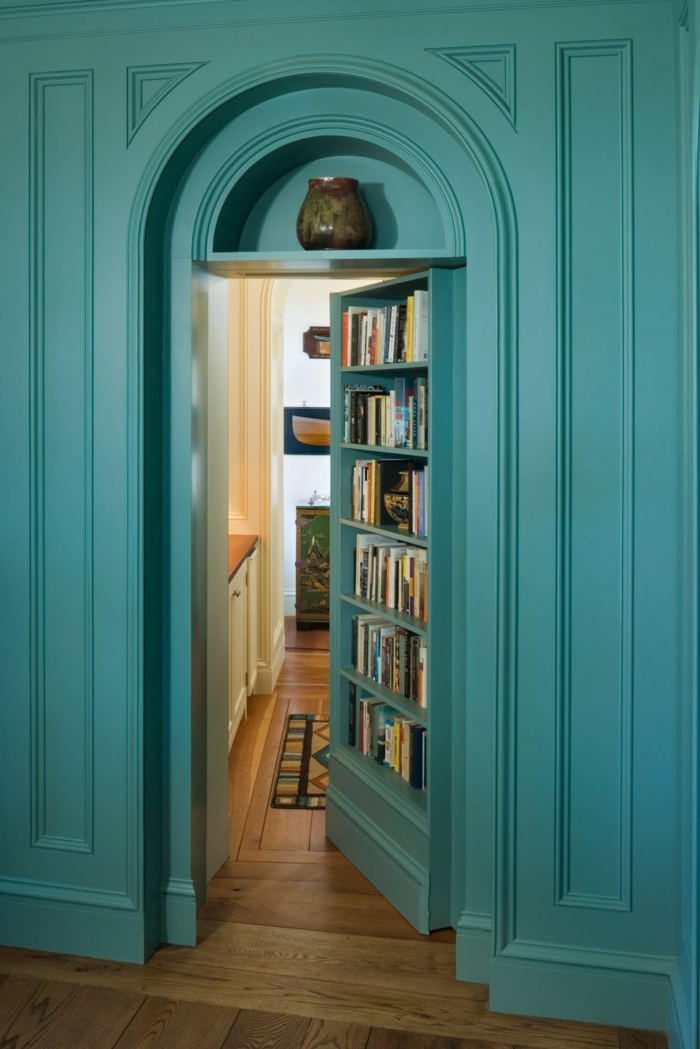 librería empotrada en una puerta, estanterias de pared, pared con madera, entrada a habitación, color turquesa, jarrón decorativo
