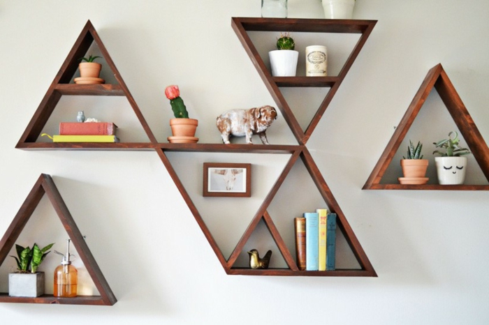librería decorativa, modulos en forma de triángulo, estanterias de madera, decoración con libros, cáctus y estatuillas