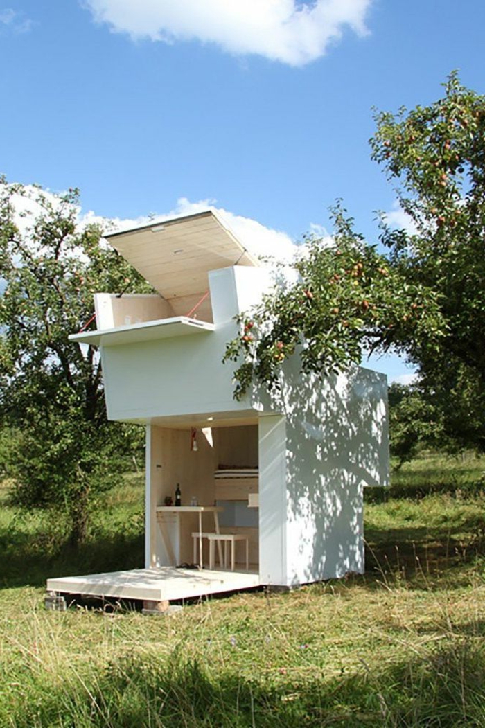 mini casa, preciosa minicasa en blanco hecha de madera con paredes abatibles, ideas para optimizar espacios pequsños 
