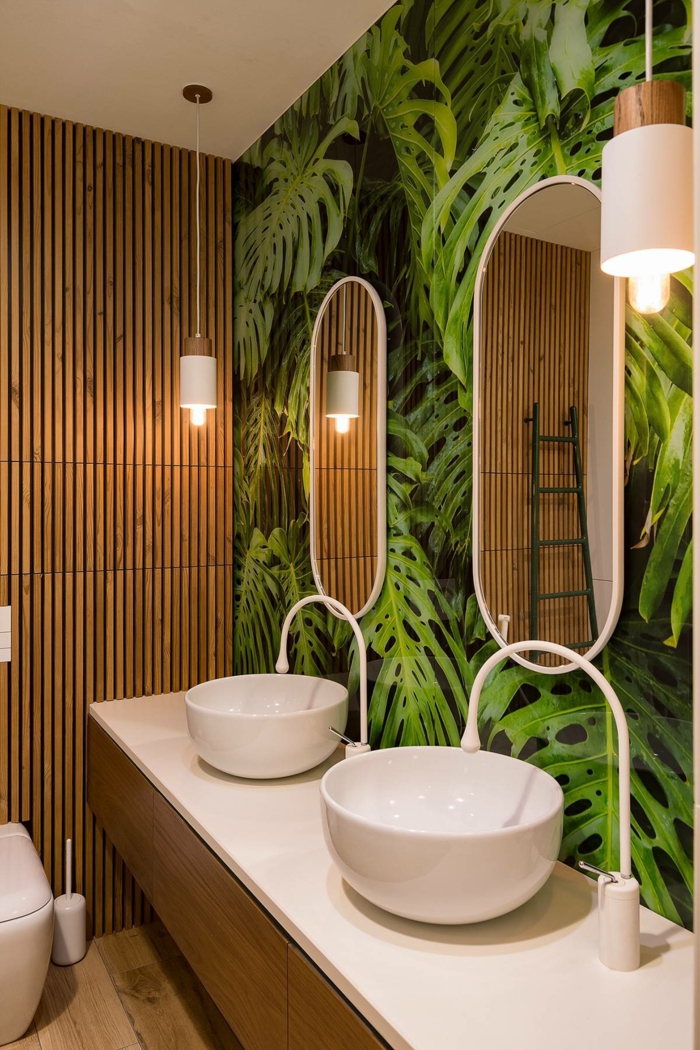 baño pequeño, armario baño, papel pintado con palmeras, dos lavabos redondos, pared de madera, lámparas colgantes