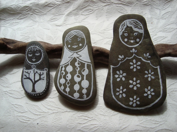 manualidades con piedras, piedras naturales en gris oscuro, pintadas con pintura acrilica, imagen de matryoshka rusa