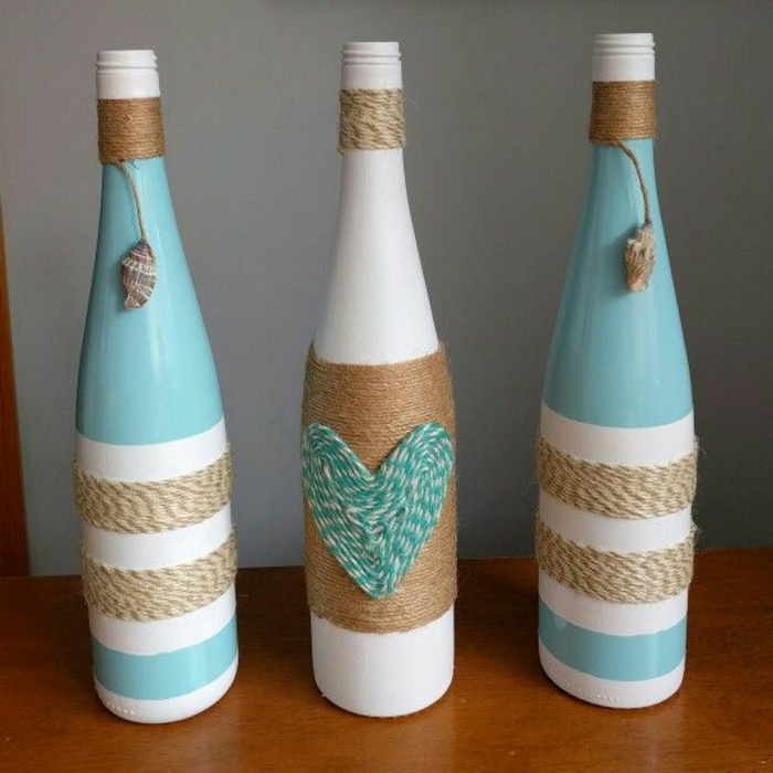 tres botellas decoradas con hilo de cañamo, botellas en blanco, azul y beige, interesante idea para decorar la casa con materiales reciclados