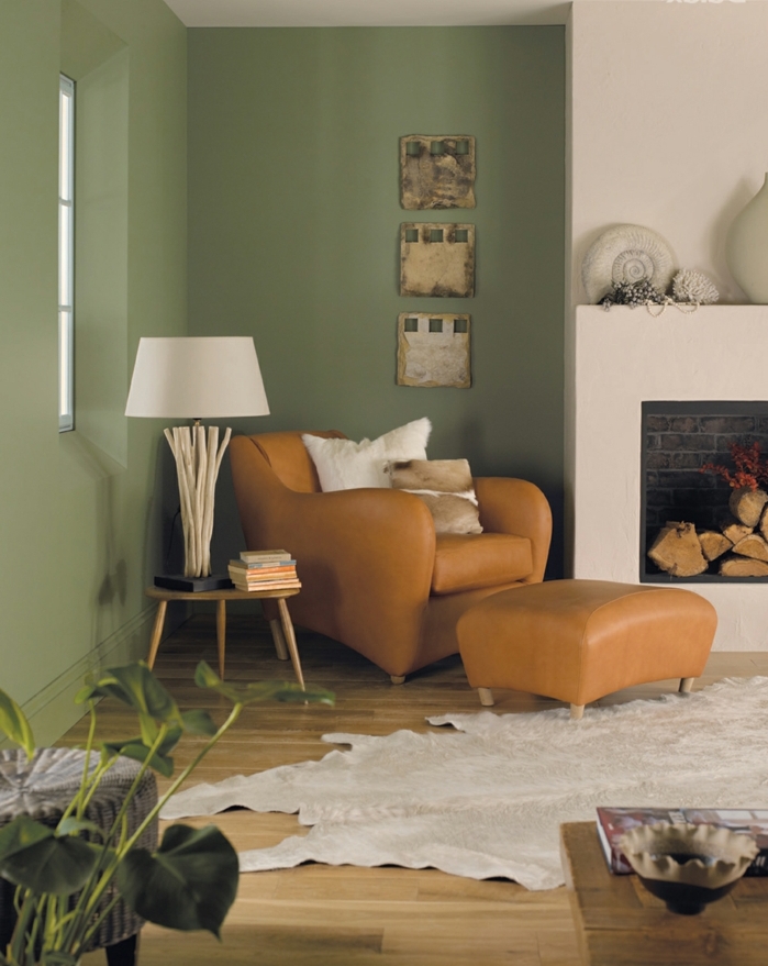 estilo rústico decoración, pintura para paredes, combinación de verde seco y blanco, sillón de piel, chimenea y alfombra piel de vaca