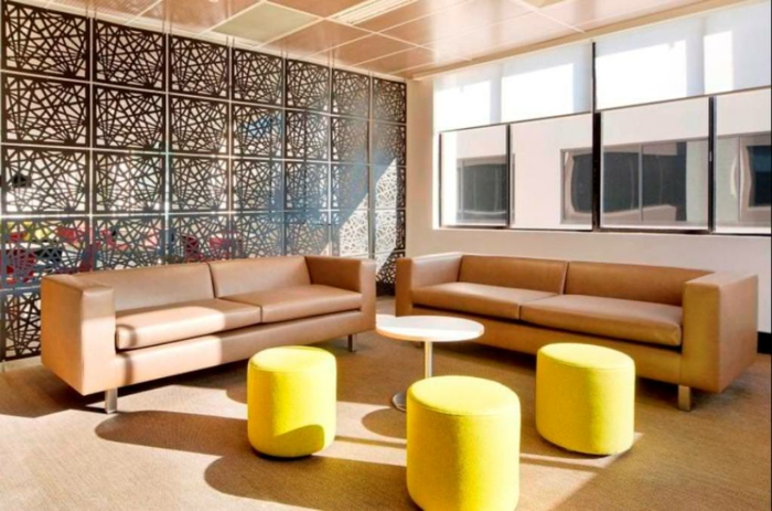 separar ambientes, grande salón con taburetes pequeños en amarillo, dos sofás en color ocre tapizado de piel