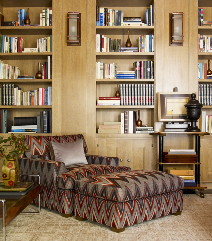 decoración vintage, lugar de lectura con sofá cama en gris y rojo, biblioteca grande con lámparas, suelo con moqueta