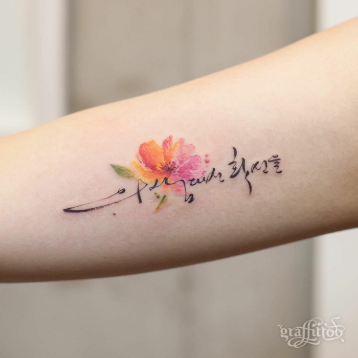 flor de loto tatuaje, tatuaje pequeño en el antebrazo, combinación de flor de acuarela con texto en cursiva negro