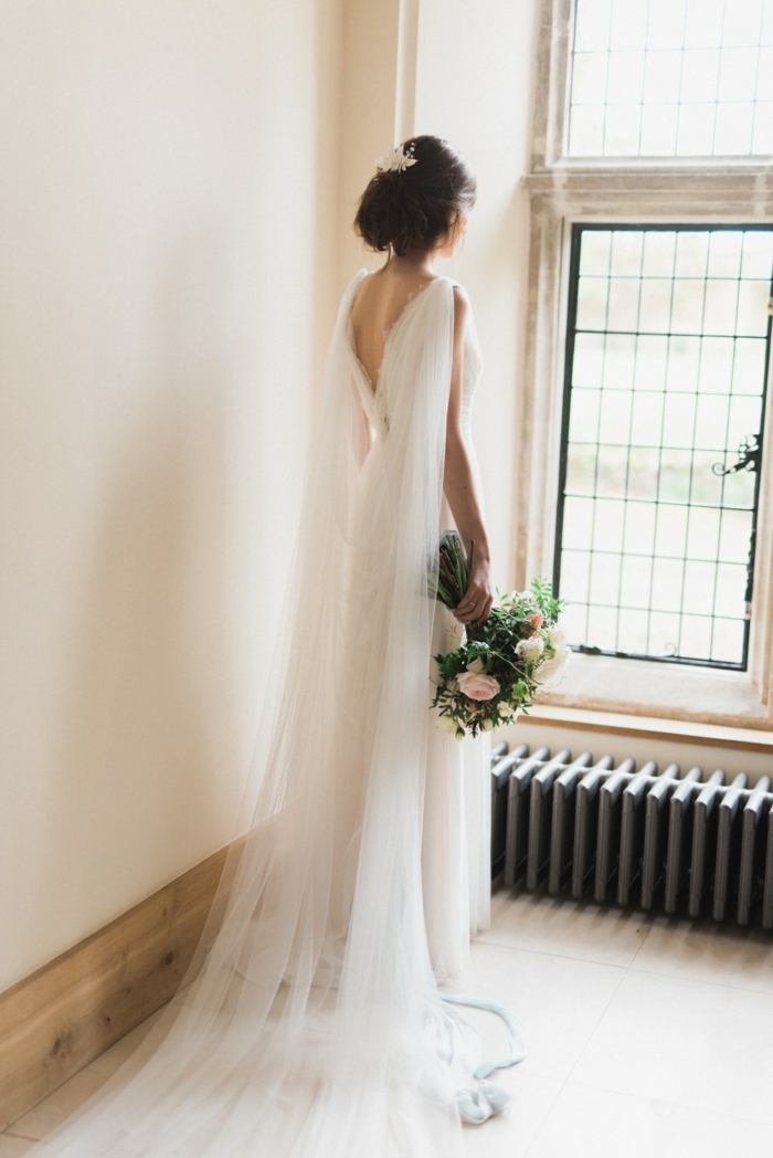 vestidos de novia modernos, vestido simple de corte princesa, peo recogido con grande velo, ramo de flores bonito 