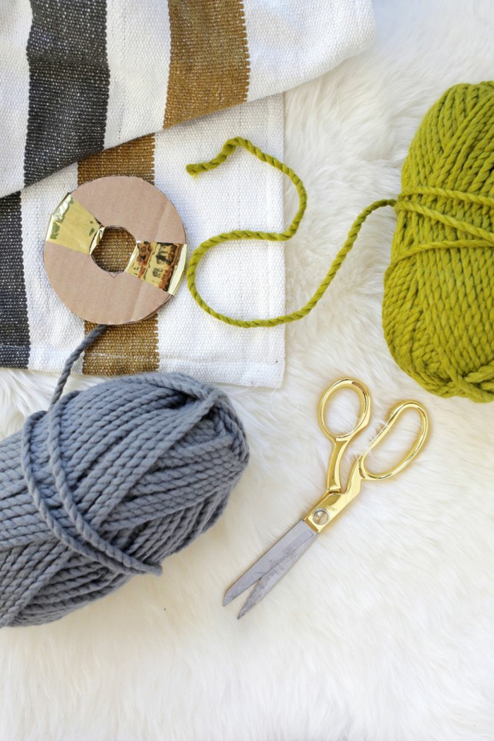 como hacer pompones de lana, materiales necesarios, hilo en gris y verde, tijeras, manta de diseño sencillo 