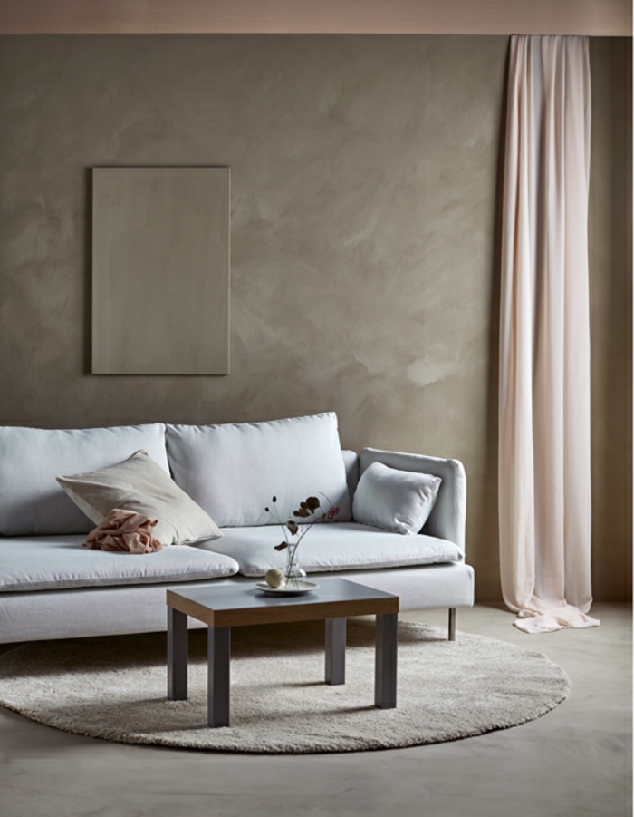 salon de encanto decorado en tonos pasteles, paredes en beige mate, cortinas aireadas en color rosa y sofa en color gris