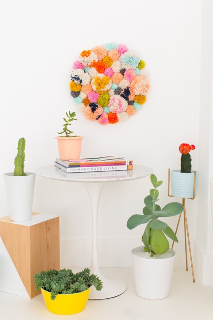 manualidades con pompones divertidas, como decorar la pared con pompones hechos a mano, bolas de lana en diferentes colores 