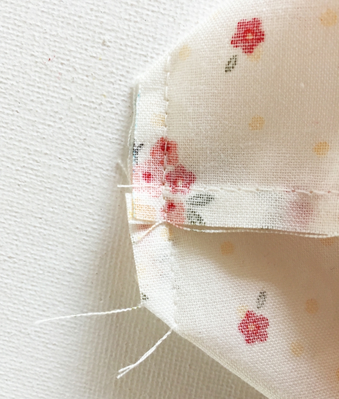 ideas cojines para bebes, ideas para hacer embalaje casero paso a paso, tela en beige con motivos florales cosida con punto simple 