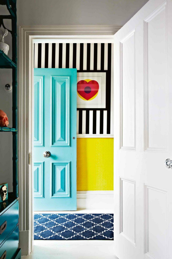 recibidores pequeños de encanto, entrada en colores llamativos, puerta en color aguamarina, pared con papel pintado en rayas en blanco y negro