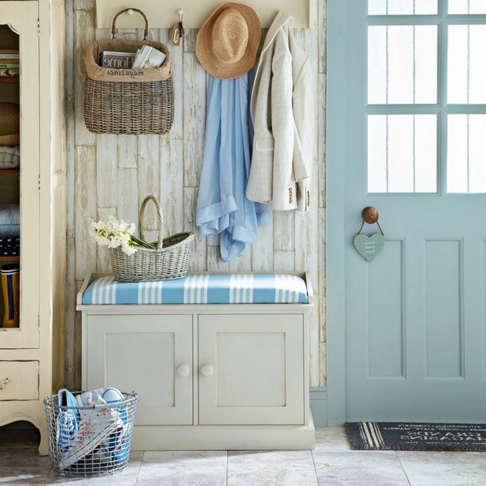 recibidores decorados en tonos claros y frescos, armario de madera con asiento, puerta pintada en azul 