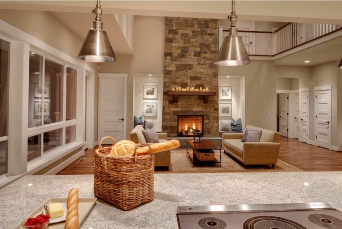 interior en colores calidos y claros, cocinas abiertas al salon de estilo moderno, barra grande funcional, sala de estar con chimenea de leña