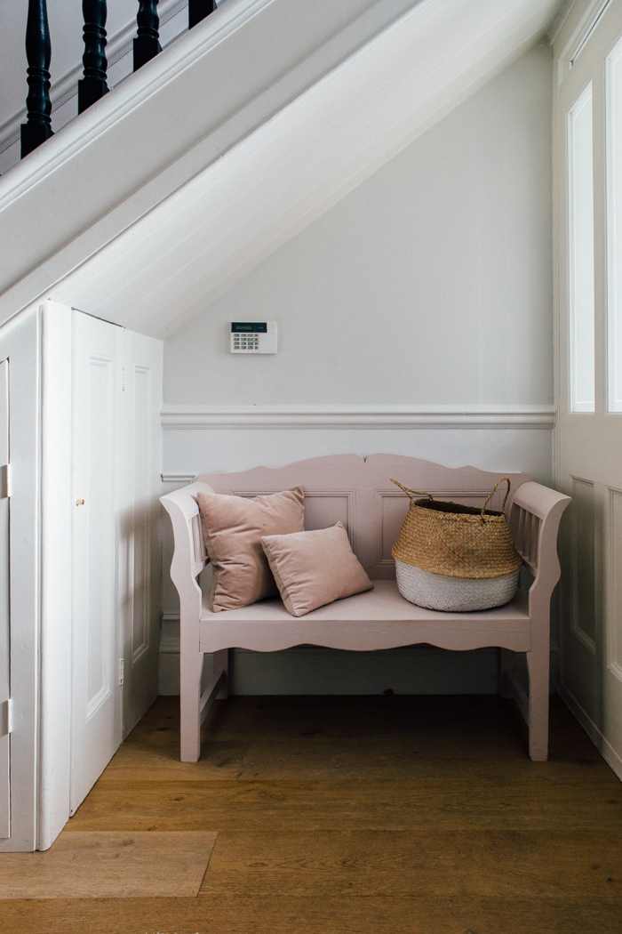 pequeños recibidores con un solo muebles, banco de época pintado en color rosa, cojines decorativos y cesta de mimbre